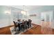 Dining room with hardwood floors, modern chandelier, light blue walls and is connected to another room at 806 Linwood Ter, Lutz, FL 33549