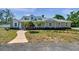 Charming home featuring a landscaped front yard, curved walkway, and a light gray exterior paint at 806 Linwood Ter, Lutz, FL 33549