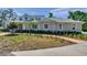 Beautifully landscaped front yard of a gray home, with a curved walkway and mature trees at 806 Linwood Ter, Lutz, FL 33549
