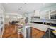 Open kitchen with an island, stainless steel appliances, hardwood floors, black countertops, and light blue walls at 806 Linwood Ter, Lutz, FL 33549