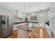 Gourmet kitchen with an island, stainless steel refrigerator, light blue walls, hardwood floors and countertops at 806 Linwood Ter, Lutz, FL 33549