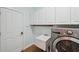 Well-equipped laundry room featuring washer, dryer, storage cabinets, and practical utility sink at 806 Linwood Ter, Lutz, FL 33549