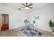 Bright home office featuring neutral walls, a glass desk on a patterned rug, and a modern ceiling fan at 806 Linwood Ter, Lutz, FL 33549