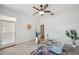 Stylish office features a glass desk with a blue accent chair, modern fan, and ample natural light at 806 Linwood Ter, Lutz, FL 33549