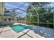 Relaxing screened-in pool with gray pavers surrounded by lush trees at 806 Linwood Ter, Lutz, FL 33549