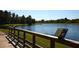 Beautiful pond view from wooden deck, featuring lush green surroundings and informative signage at 8116 Painted Sky Pl, Land O Lakes, FL 34637