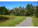 Scenic walking path by a pond surrounded by lush landscaping under a clear blue sky at 8116 Painted Sky Pl, Land O Lakes, FL 34637