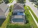 Aerial view of home featuring a private screened-in pool, well-maintained lawn, and mature trees at 9107 Gablewood Pl, Land O Lakes, FL 34638