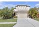 Two-story home featuring a two-car garage, well-maintained lawn, and lush tropical landscaping at 9107 Gablewood Pl, Land O Lakes, FL 34638