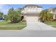 Two-story home with a two-car garage and tropical landscaping on a sunny day at 9107 Gablewood Pl, Land O Lakes, FL 34638
