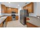 A kitchen with stainless steel appliances, wooden cabinets, tile flooring, and ample counter space at 9107 Gablewood Pl, Land O Lakes, FL 34638