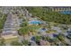 Community featuring homes, a sparkling blue pool, clubhouse, and green spaces with mature trees at 9205 English Oaks Ln, Riverview, FL 33578