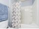 Bright bathroom featuring a tub with a shower and a pretty floral curtain at 9205 English Oaks Ln, Riverview, FL 33578