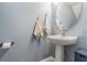 Powder room featuring a pedestal sink, chrome fixtures, and a decorative mirror at 9205 English Oaks Ln, Riverview, FL 33578