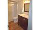 Bathroom featuring wood floors, neutral paint, vanity with marble counters, and glass enclosed shower at 940 Virginia St # 304, Dunedin, FL 34698