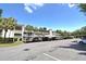 Condominium building with covered parking, palm trees, and a bright blue sky at 940 Virginia St # 304, Dunedin, FL 34698