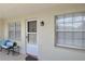 Charming entrance to unit featuring a bench, storm door and updated fixtures at 940 Virginia St # 304, Dunedin, FL 34698