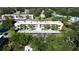 Aerial view of condo building with palm trees, parking, and lush landscaping at 940 Virginia St # 304, Dunedin, FL 34698