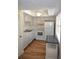 Efficient kitchen with white appliances, cabinets, and wood look flooring at 940 Virginia St # 304, Dunedin, FL 34698