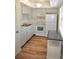 Efficient kitchen with white appliances, cabinets, and wood look flooring at 940 Virginia St # 304, Dunedin, FL 34698