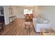Well-lit living room featuring wood look floors, couch and dining area at 940 Virginia St # 304, Dunedin, FL 34698