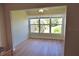 Bright living room with wood floors, neutral paint, and large windows with tree views at 940 Virginia St # 304, Dunedin, FL 34698