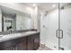 Bathroom featuring a glass door shower, dual sinks with granite countertops, and a modern vanity at 11426 Sage Canyon Dr, Riverview, FL 33578
