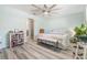 Bedroom featuring modern ceiling fan, gray flooring, and a comfortable bed with a decorative bench at 11426 Sage Canyon Dr, Riverview, FL 33578