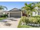 Single-Gathering home boasts a spacious garage, well-maintained lawn, and mature palm trees at 11426 Sage Canyon Dr, Riverview, FL 33578