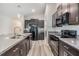 Modern kitchen boasts stainless steel appliances, a central island, and dark wood cabinetry at 11426 Sage Canyon Dr, Riverview, FL 33578