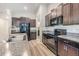 Modern kitchen features stainless steel appliances, granite countertops, and dark wood cabinetry at 11426 Sage Canyon Dr, Riverview, FL 33578