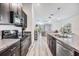 Modern kitchen overlooks the living area and features stainless steel appliances and granite countertops at 11426 Sage Canyon Dr, Riverview, FL 33578