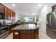 Spacious kitchen features stainless steel appliances, wooden cabinetry, and a center island with a stone countertop at 1105 Venetian Harbor Ne Dr, St Petersburg, FL 33702