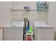 Functional laundry room with washer, dryer, and shelving for supplies at 1105 Venetian Harbor Ne Dr, St Petersburg, FL 33702