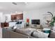 An open living area with a modern grey couch, stylish decor, and seamless access to the kitchen and dining space at 1105 Venetian Harbor Ne Dr, St Petersburg, FL 33702