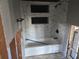 Partially renovated bathroom featuring new marble tiling around tub with built in shelves at 125 18Th Nw St, Ruskin, FL 33570