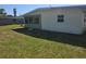 View of home's exterior featuring screened windows and a spacious backyard at 125 18Th Nw St, Ruskin, FL 33570