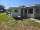 View of home's exterior featuring a door and multiple windows with a spacious yard at 125 18Th Nw St, Ruskin, FL 33570