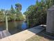 Scenic waterfront view with a concrete pathway, lush trees, and canal access at 125 18Th Nw St, Ruskin, FL 33570