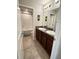 Bathroom featuring double sink vanity, granite countertop, with tiled floors, and a tub with a shower at 12717 Lemon Pepper Dr, Riverview, FL 33578