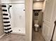 Open bathroom view: shower with striped curtain, a toilet area featuring decorative wall art at 12717 Lemon Pepper Dr, Riverview, FL 33578