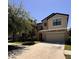 Two-story home with a beige exterior, a two-car garage, well-manicured lawn, and nicely landscaped yard at 12717 Lemon Pepper Dr, Riverview, FL 33578