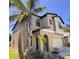 Two-story home with a beige exterior, a two-car garage, well-manicured lawn, and nicely landscaped yard at 12717 Lemon Pepper Dr, Riverview, FL 33578