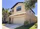 Two-story home featuring a neutral color palette, two-car garage, and manicured shrubbery enhancing the curb appeal at 12717 Lemon Pepper Dr, Riverview, FL 33578