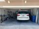 Attached two-car garage with storage, work bench, and a parked white vehicle inside at 12717 Lemon Pepper Dr, Riverview, FL 33578