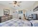 Spacious bedroom with ceiling fan, dresser with mirror, and access to the restroom at 12965 Satin Lily Dr, Riverview, FL 33579