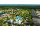 Aerial view of a community with a pool, park, clubhouse, and pond surrounded by lush greenery at 12965 Satin Lily Dr, Riverview, FL 33579