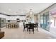 Open floor plan of kitchen and dining area, featuring white cabinets, a large island, and sliding glass doors at 12965 Satin Lily Dr, Riverview, FL 33579