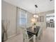 Well-lit dining room featuring neutral walls, tile floor, and a modern chandelier above the dining table at 12965 Satin Lily Dr, Riverview, FL 33579