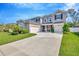 Charming two-story home featuring a three-car garage, well-manicured lawn, and a beautifully landscaped front yard at 12965 Satin Lily Dr, Riverview, FL 33579